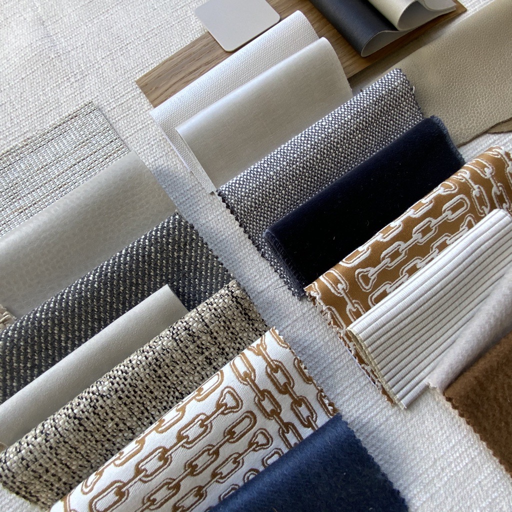 Selection of brown and grey fabrics folded neatly on a white surface