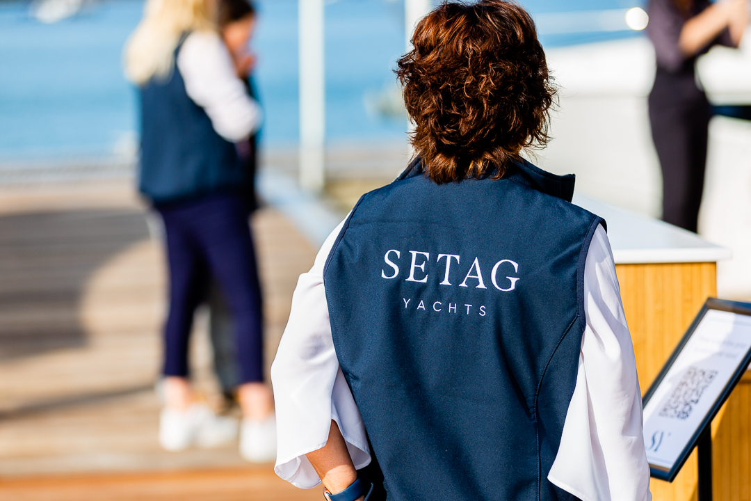 setag staff in branded jackets on a marina talking to customers