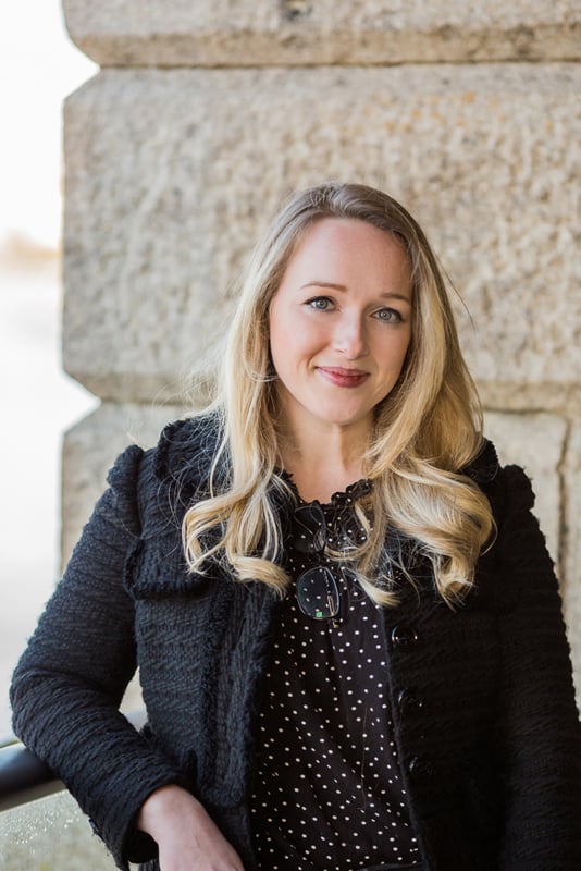 Portrait photograph of Sarah Luck in the sunshine leaning against a wall