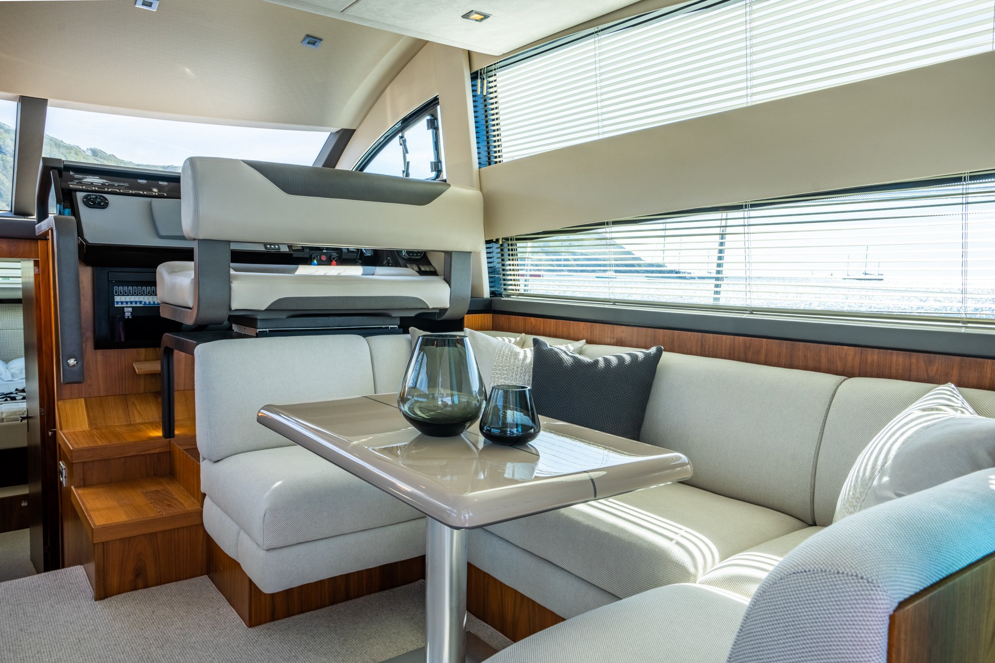 Interior saloon of a Squadron 42 yacht with brown wood and cream upholstery