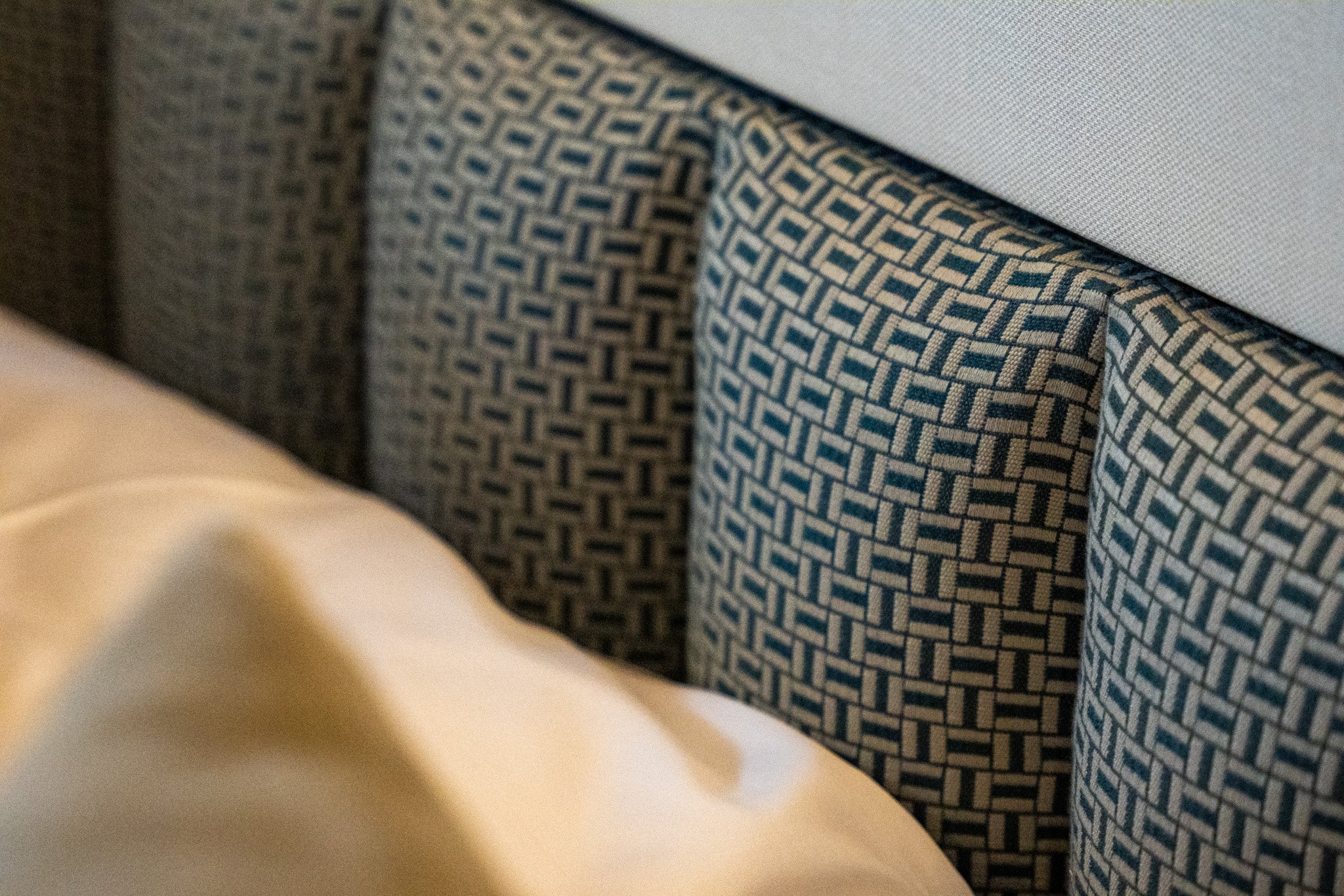 Up close of a padded navy and grey geometric fabric board for a yacht interior
